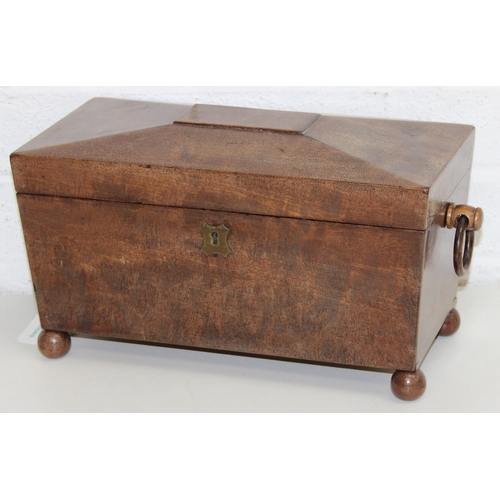 293 - An antique mahogany sarcophagus tea caddy with turned feet and ring handles, three compartment inter... 