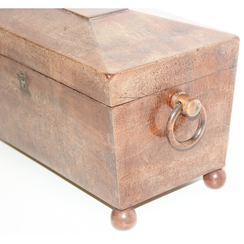 293 - An antique mahogany sarcophagus tea caddy with turned feet and ring handles, three compartment inter... 