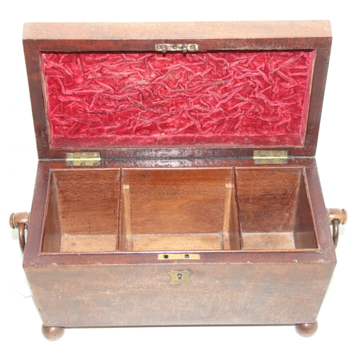 293 - An antique mahogany sarcophagus tea caddy with turned feet and ring handles, three compartment inter... 