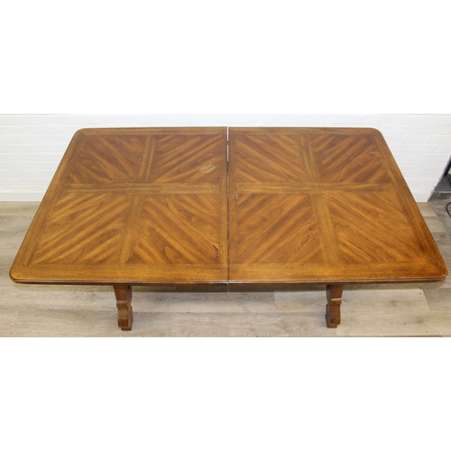86 - An early 20th century walnut extending dining table with decorative Spanish Baroque style base, with... 