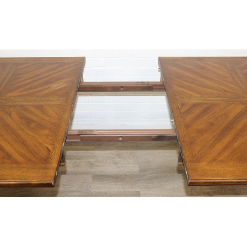 86 - An early 20th century walnut extending dining table with decorative Spanish Baroque style base, with... 