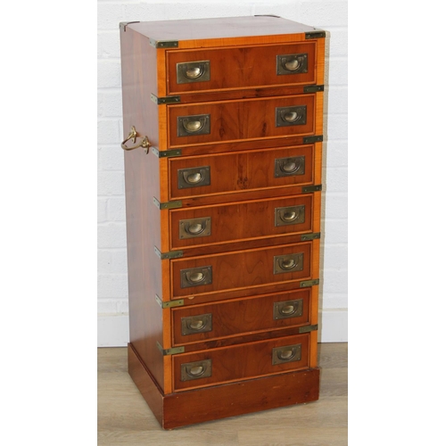 19 - A modern yew wood effect campaign chest with seven drawers and recessed brass campaign style handles... 