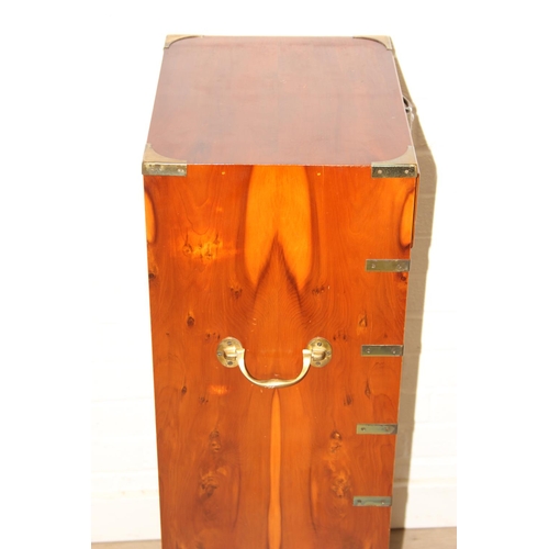 19 - A modern yew wood effect campaign chest with seven drawers and recessed brass campaign style handles... 