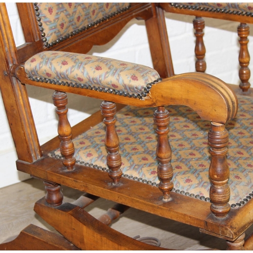 187 - An early 20th century rocking chair with decorative floral upholstery, possibly American, 107cm tall