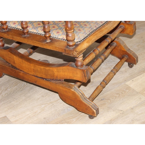 187 - An early 20th century rocking chair with decorative floral upholstery, possibly American, 107cm tall