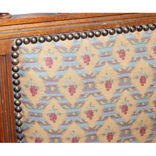 187 - An early 20th century rocking chair with decorative floral upholstery, possibly American, 107cm tall