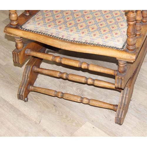 187 - An early 20th century rocking chair with decorative floral upholstery, possibly American, 107cm tall