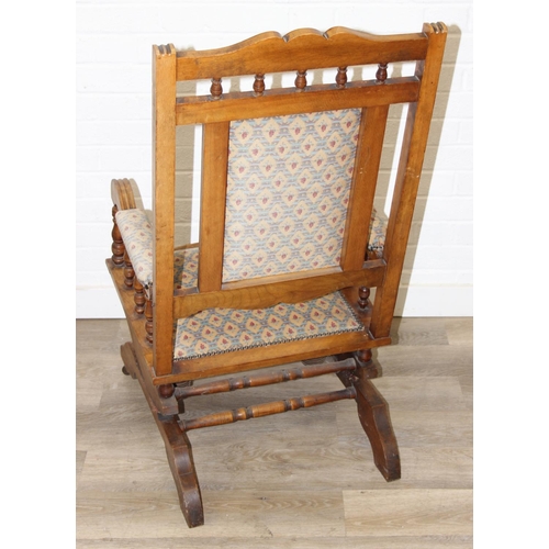 187 - An early 20th century rocking chair with decorative floral upholstery, possibly American, 107cm tall