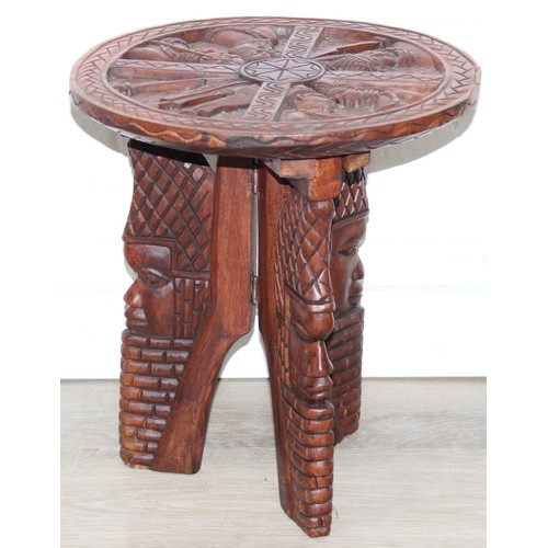 66 - Three African carved hardwood folding tables, the tops carved with elephants, rhinos, giraffes etc, ... 