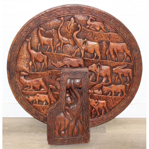 66 - Three African carved hardwood folding tables, the tops carved with elephants, rhinos, giraffes etc, ... 
