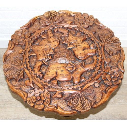 66 - Three African carved hardwood folding tables, the tops carved with elephants, rhinos, giraffes etc, ... 