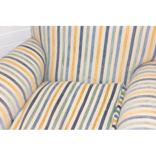 75 - In the manner of Howard & Sons, an antique deep seated armchair with multi-coloured stripey upholste... 