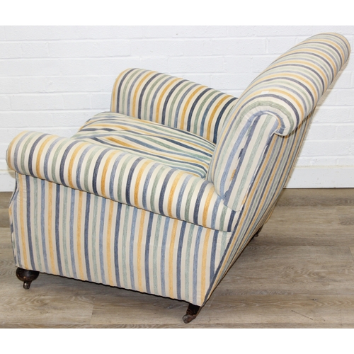 75 - In the manner of Howard & Sons, an antique deep seated armchair with multi-coloured stripey upholste... 