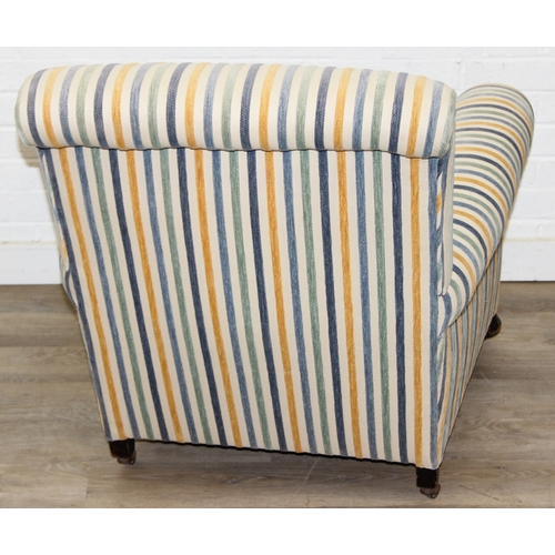 75 - In the manner of Howard & Sons, an antique deep seated armchair with multi-coloured stripey upholste... 
