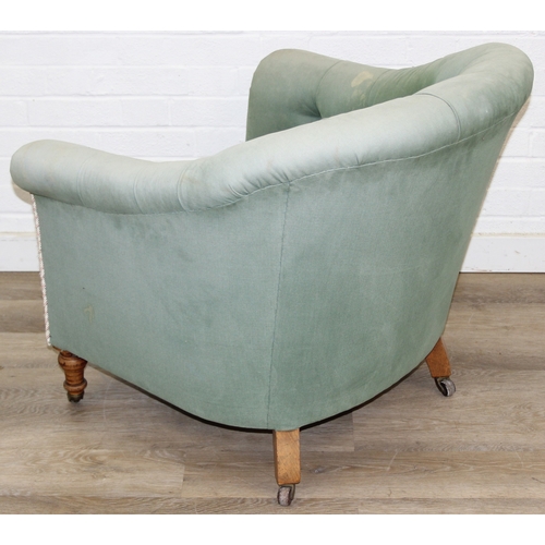 97 - An antique green upholstered tub chair with button backed upholstery, turned wooden legs and brass a... 