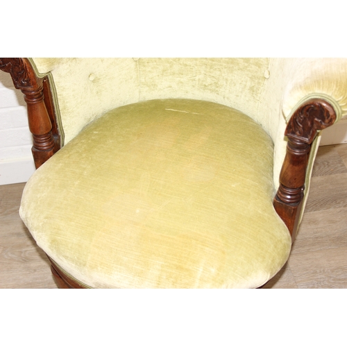 68 - A Victorian tub chair or armchair with green buttoned velvet upholstery and exposed carved wooden fr... 
