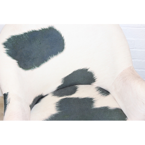 65 - A pair of retro style Ringo armchairs with black painted wooden legs, Friesian cow hide style uphols... 