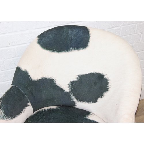 65 - A pair of retro style Ringo armchairs with black painted wooden legs, Friesian cow hide style uphols... 