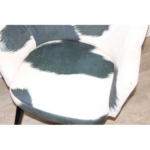 65 - A pair of retro style Ringo armchairs with black painted wooden legs, Friesian cow hide style uphols... 