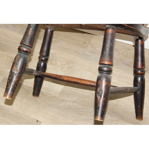 107 - An antique farmhouse stick-back Windsor armchair with elm seat, 19th century, with some very rustic ... 