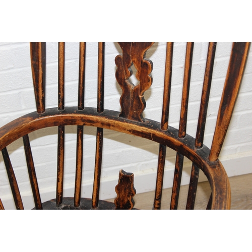 107 - An antique farmhouse stick-back Windsor armchair with elm seat, 19th century, with some very rustic ... 