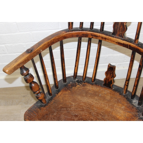 107 - An antique farmhouse stick-back Windsor armchair with elm seat, 19th century, with some very rustic ... 