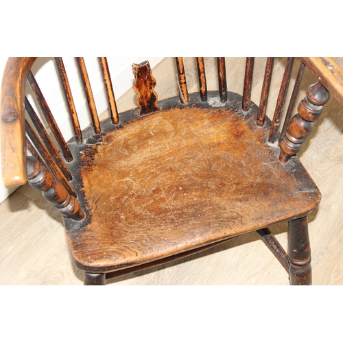 107 - An antique farmhouse stick-back Windsor armchair with elm seat, 19th century, with some very rustic ... 