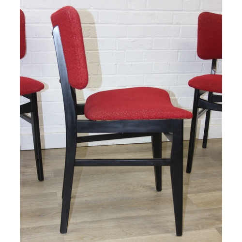 99 - A retro 1950's extending dining table and four chairs, the chairs with red fabric upholstery, seemin... 
