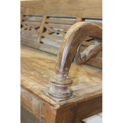 73 - A large hallway or conservatory garden bench with cut our back, scroll arms and turned legs, 20th ce... 