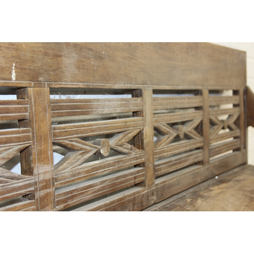 73 - A large hallway or conservatory garden bench with cut our back, scroll arms and turned legs, 20th ce... 