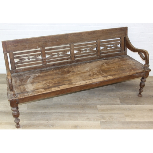 73 - A large hallway or conservatory garden bench with cut our back, scroll arms and turned legs, 20th ce... 