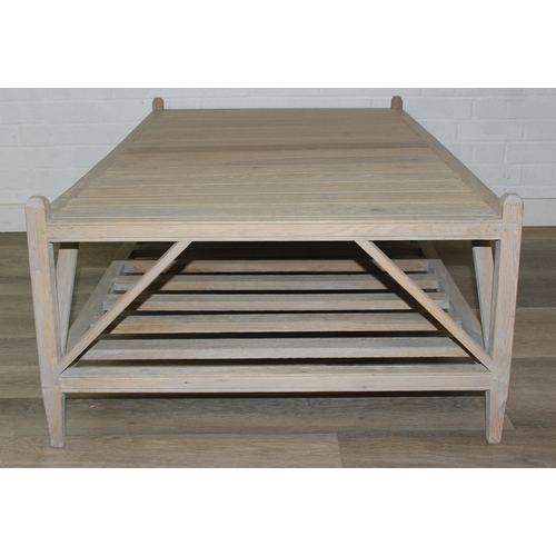 113 - A modern limed light oak coffee table with slatted undertier, no makers mark but a hand stamped bras... 