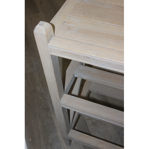 114 - A modern limed light oak side table with three tiers, a solid top tier and two slatted tiers under, ... 