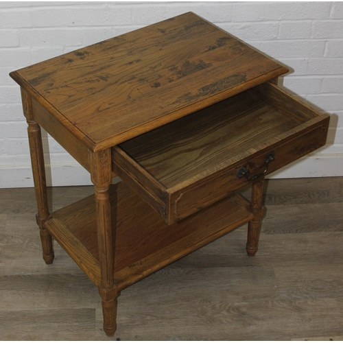 74 - A distressed oak bedside table with single drawer and brass handle, 65cm x 45cm x 75cm, one of two i... 