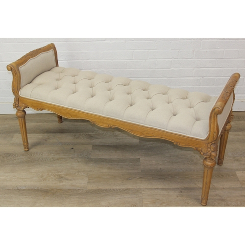 87 - An antique style window seat with oatmeal buttoned upholstery and carved wooden exposed frame, reede... 