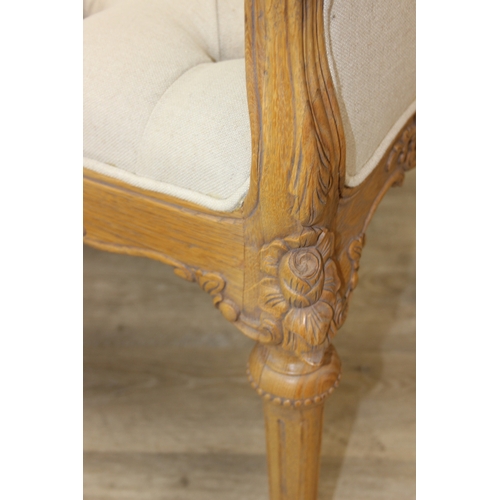 87 - An antique style window seat with oatmeal buttoned upholstery and carved wooden exposed frame, reede... 