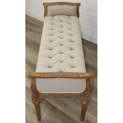87 - An antique style window seat with oatmeal buttoned upholstery and carved wooden exposed frame, reede... 