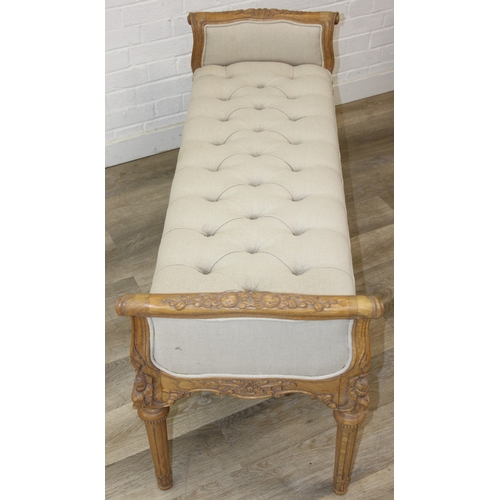 87 - An antique style window seat with oatmeal buttoned upholstery and carved wooden exposed frame, reede... 