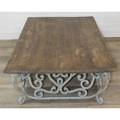 110 - A vintage low table with distressed green painted wrought iron base, the top reclaimed pine, 140cm x... 