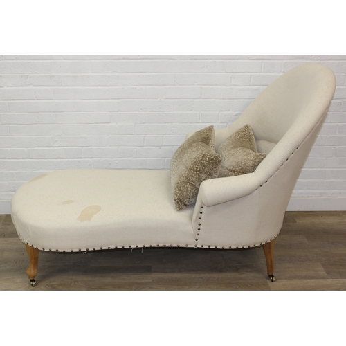 66 - Modern chaise lounge in cream upholstery, raised on blonde wood legs with brass castors, 150cm x 80c... 