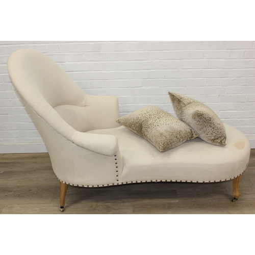 66 - Modern chaise lounge in cream upholstery, raised on blonde wood legs with brass castors, 150cm x 80c... 