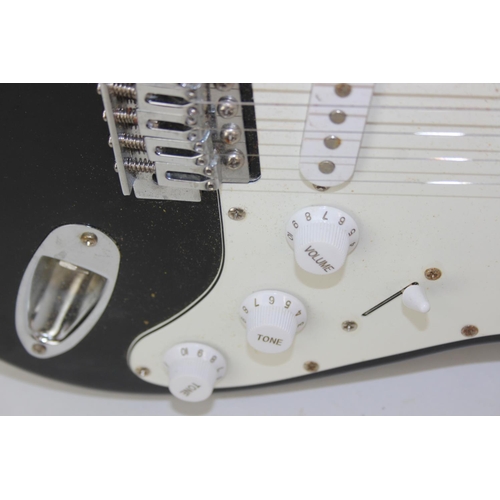 733 - A Burswood electric guitar with black body and soft shell case, 100cm long