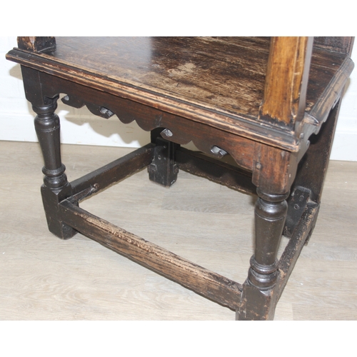 22 - An antique oak Wainscot chair with decorative top rail and carved geometric details to back, in part... 