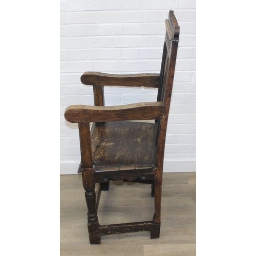 22 - An antique oak Wainscot chair with decorative top rail and carved geometric details to back, in part... 