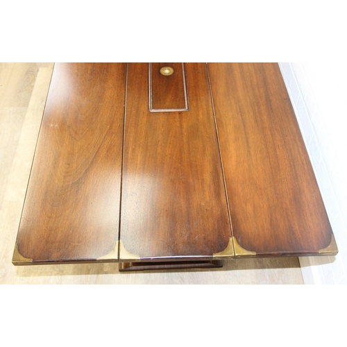 26 - A campaign style mahogany and brass drop leaf low table with brass corners and unusual central compa... 