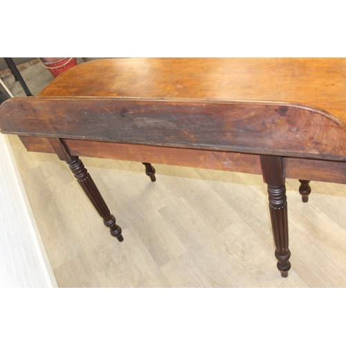 79 - A Regency period mahogany console table with long single drawer, raised back rail, all standing on t... 