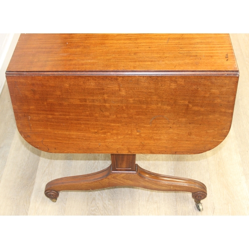 167 - A 19th century drop end mahogany sofa table with two drawers, scrolled legs with brass and ceramic c... 