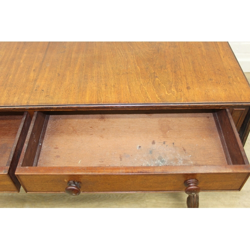 167 - A 19th century drop end mahogany sofa table with two drawers, scrolled legs with brass and ceramic c... 