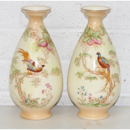 1580 - A pair of Crown Ducal vases decorated with Peacocks, each 25cm tall