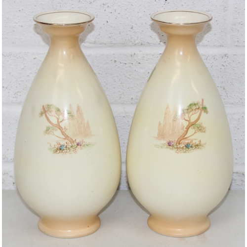 1580 - A pair of Crown Ducal vases decorated with Peacocks, each 25cm tall